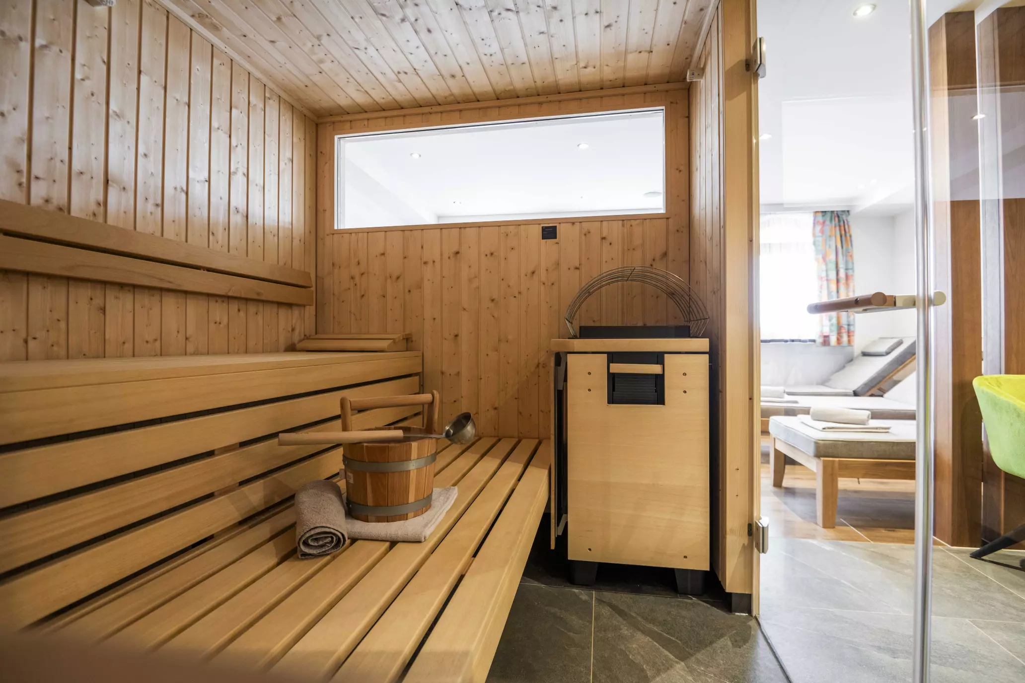 Sauna mit Saunaofen und Blick zum Ruheraum